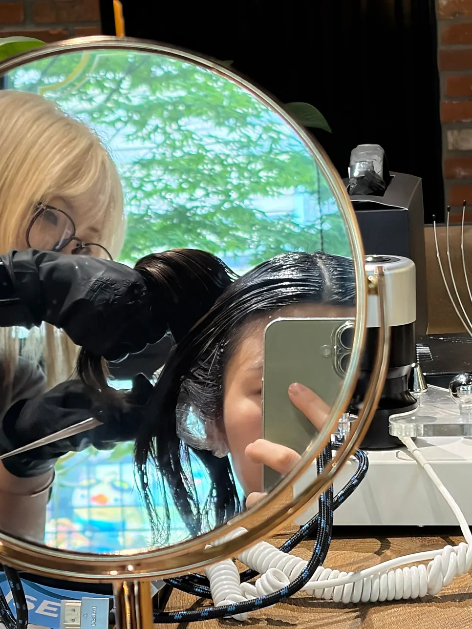 Root touch-up being applied with careful scalp protection
