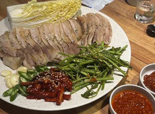 수육에 김치를 올려 먹는 보쌈 한 점