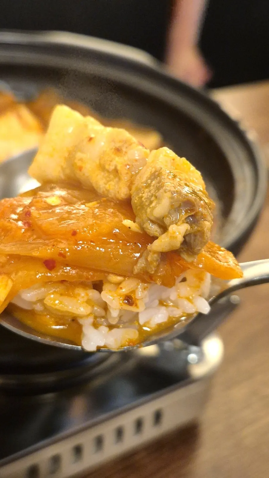 Taking a bite of pork belly wrapped in kimchi