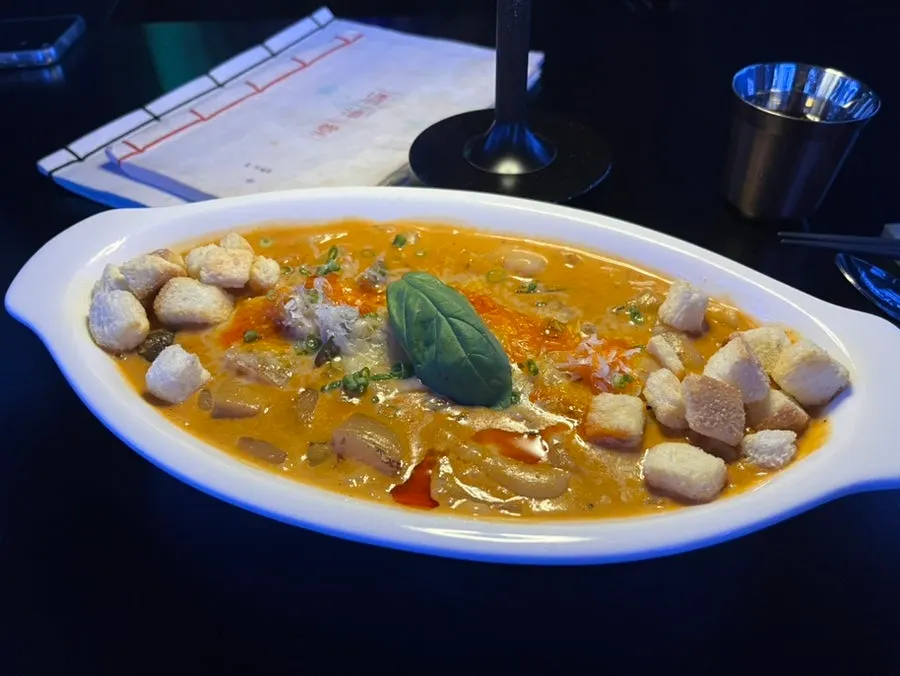 Sujebi lifted out of the spicy rosé broth