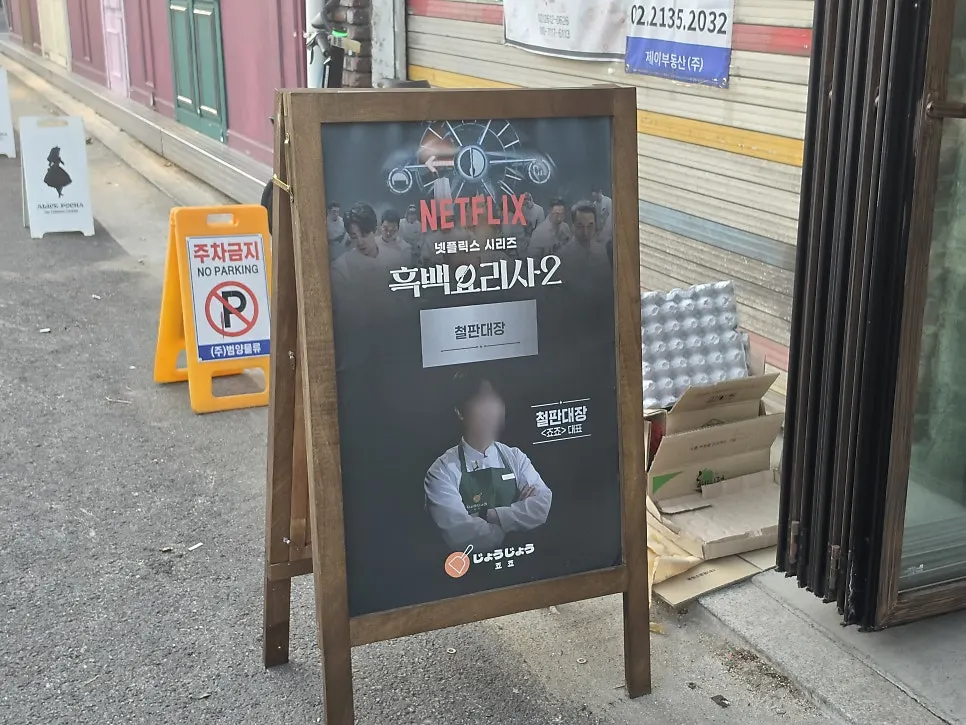 죠죠 문래점 입구의 원목 입간판과 포스터