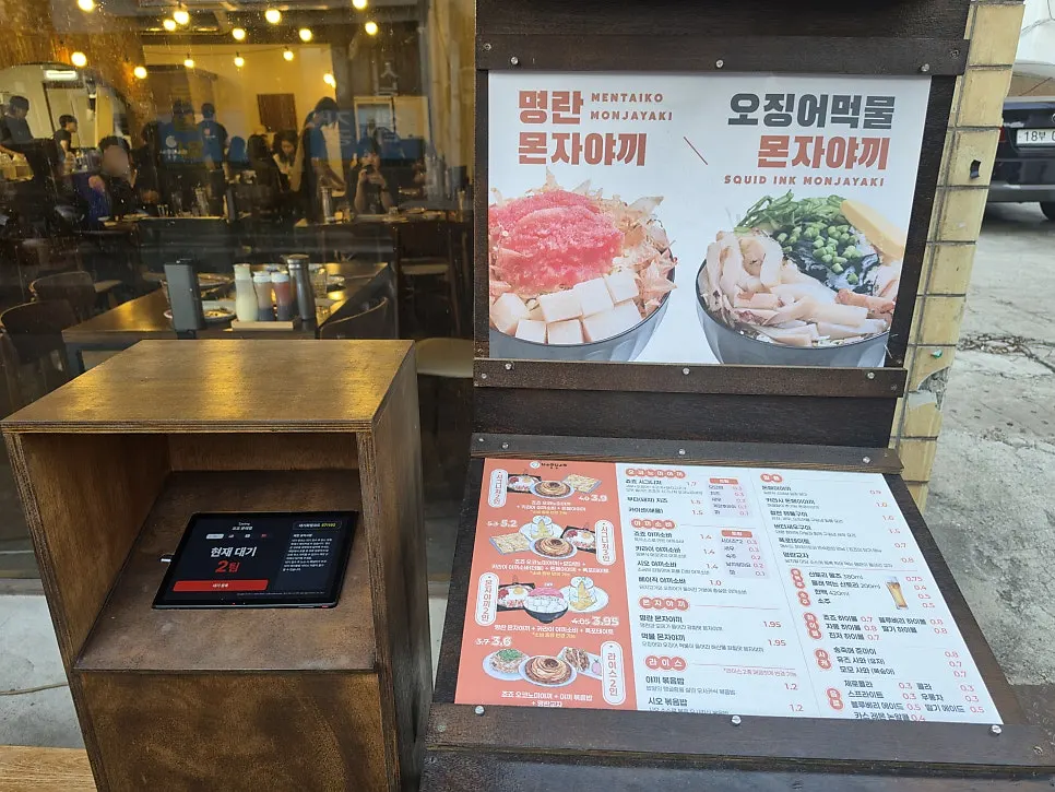 입구에 놓인 캐치테이블 대기 등록 태블릿과 대형 메뉴판