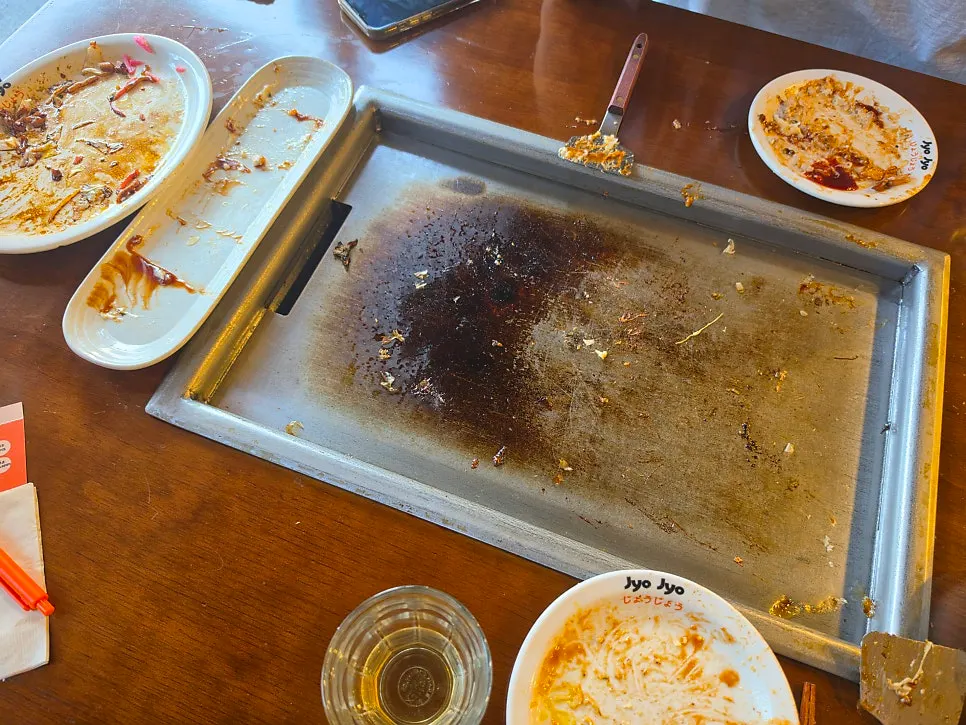 음식을 다 먹고 비워진 접시와 철판 자리