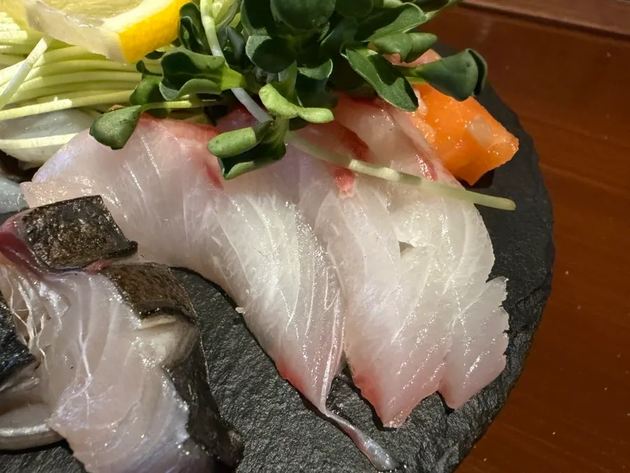 Glistening sashimi slices under the light