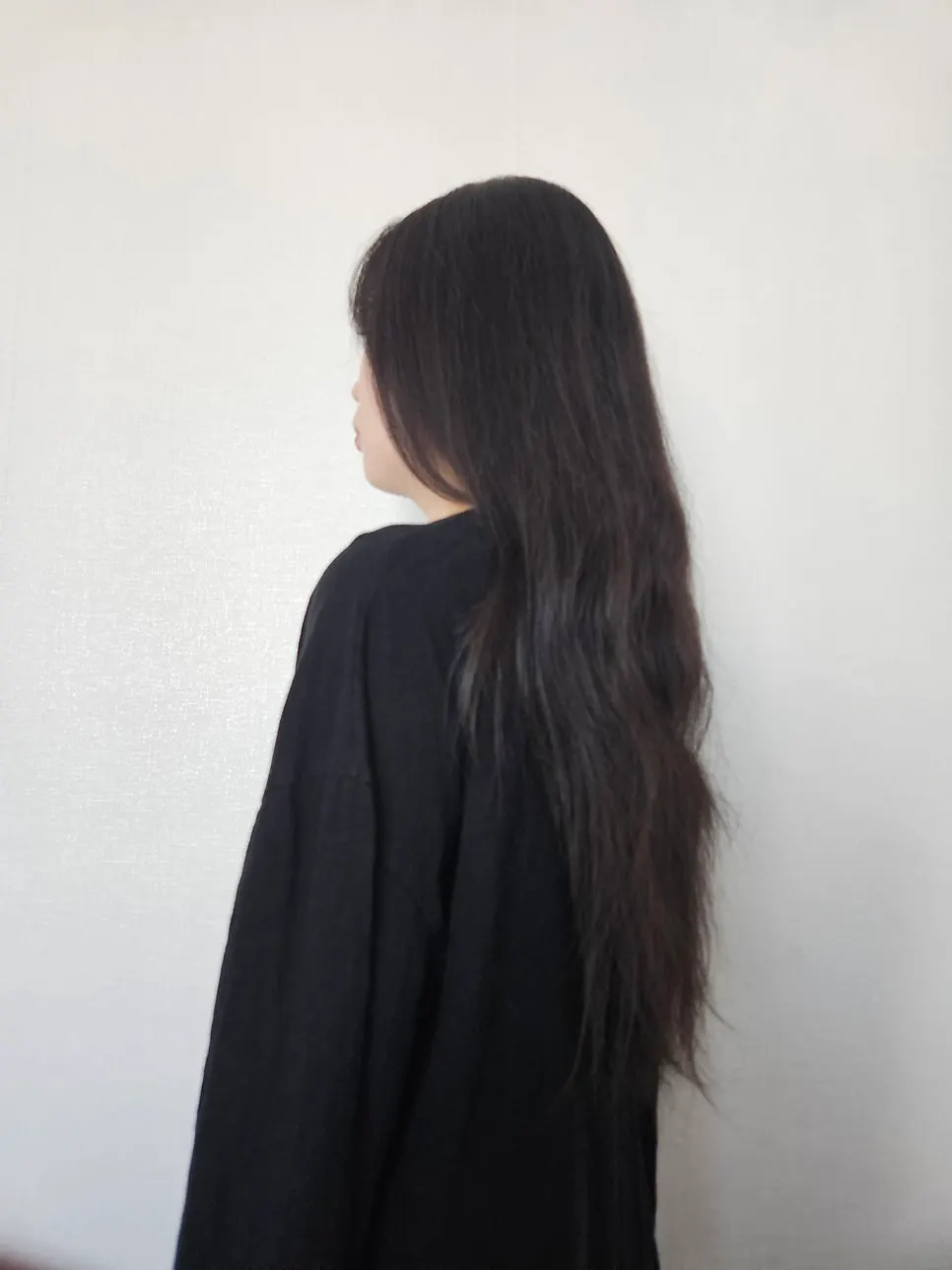 Back view of frizzy, curly hair before the treatment