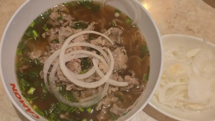 Scooping up broth from the Kkamon pho