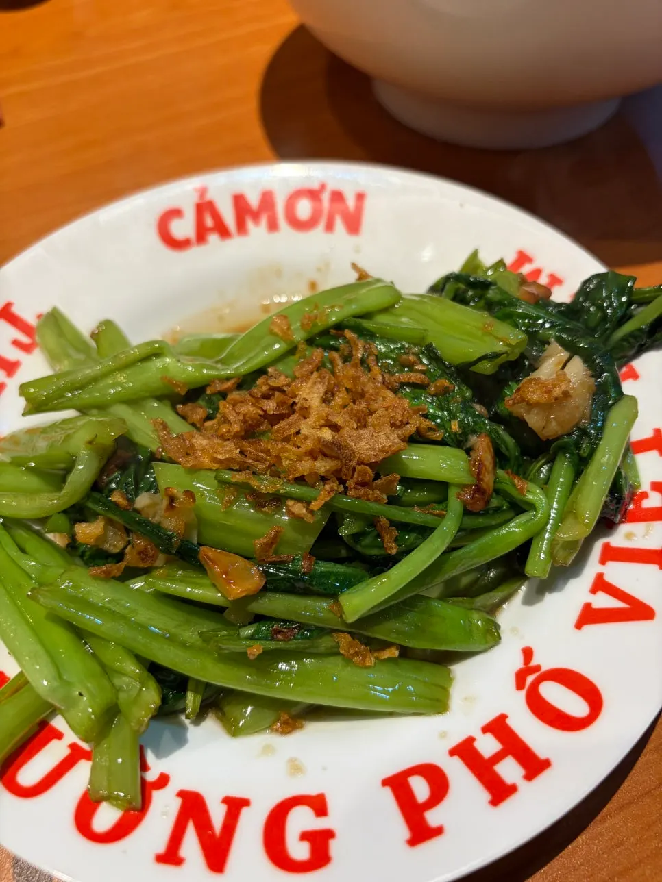 Stir-fried water spinach topped with crispy flakes
