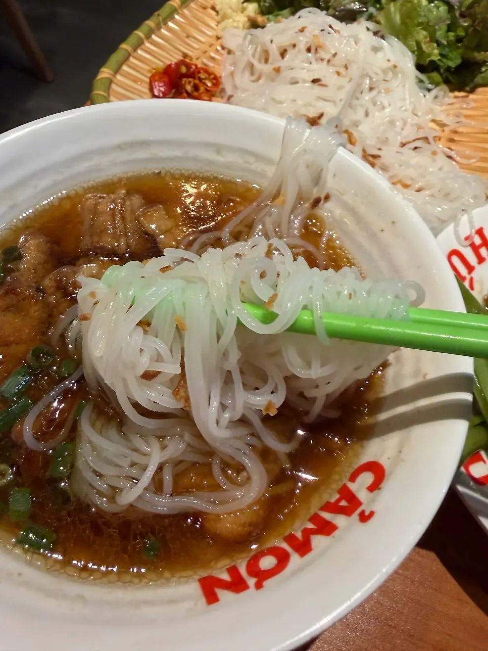 Close-up of noodles dipped in bún chả sauce