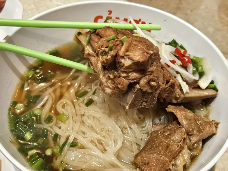 Close-up of pork backbone pho broth and noodles