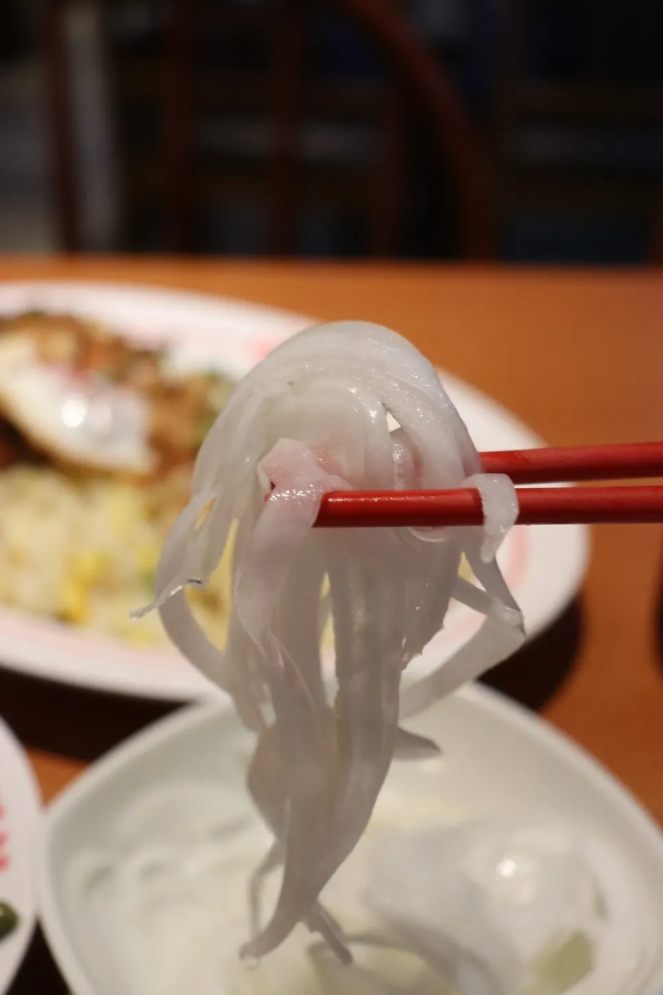 Lifting up pho noodles and broth with chopsticks