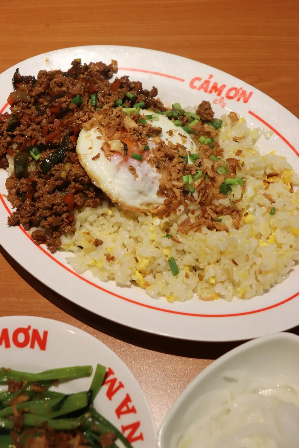 Kkamon fried rice topped with sautéed meat and a runny egg