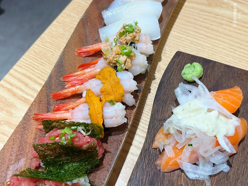 Salmon sushi topped with onion and sauce