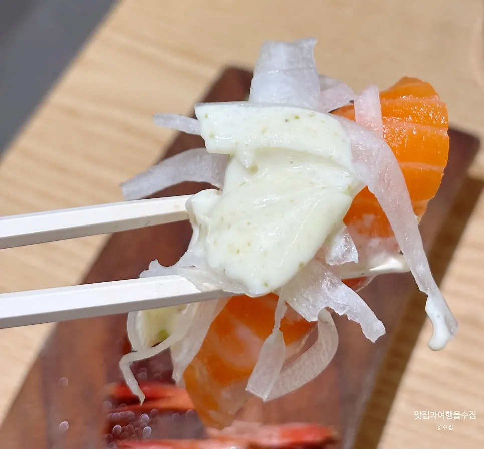 Two pieces of salmon sushi with salmon sauce