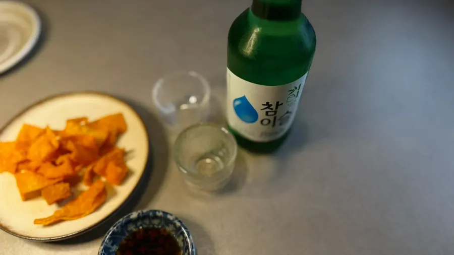 A glass of soju paired with the starter snack