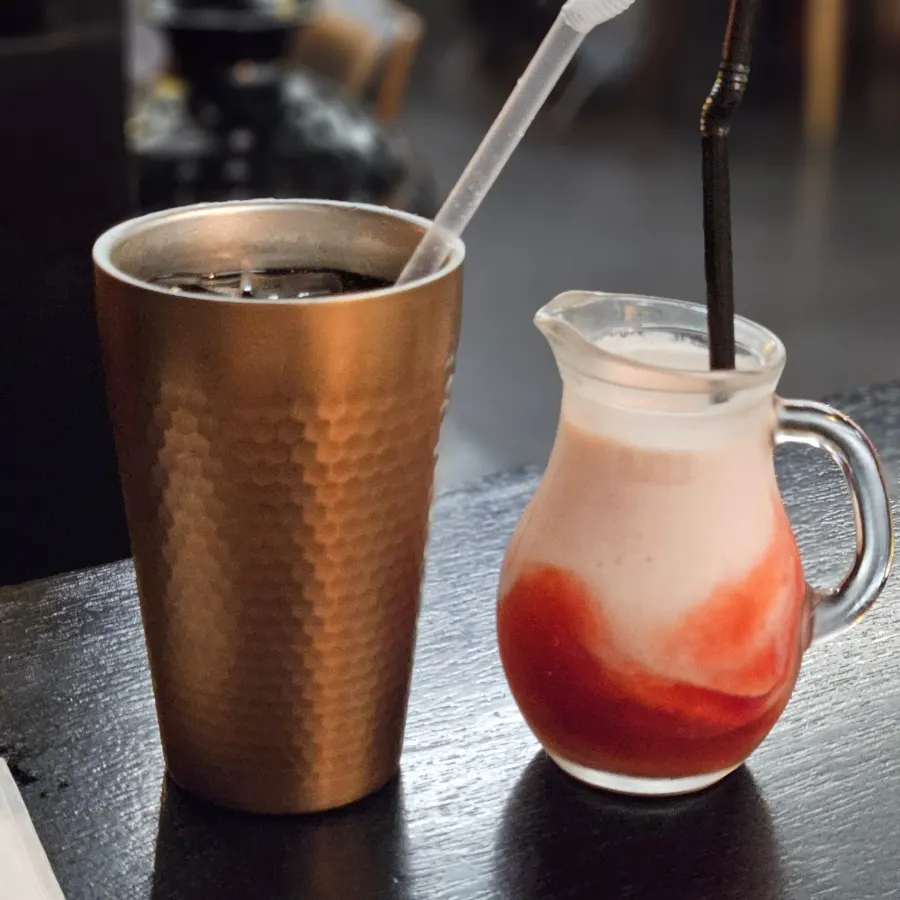 Two glasses of strawberry lassi and Diet Coke