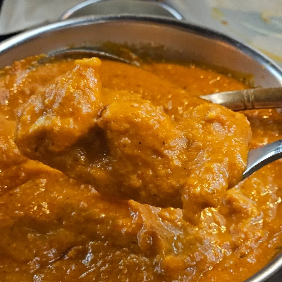 Close-up of butter chicken curry with big chunks of chicken