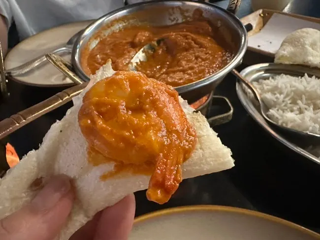 Scooping up curry wrapped in naan