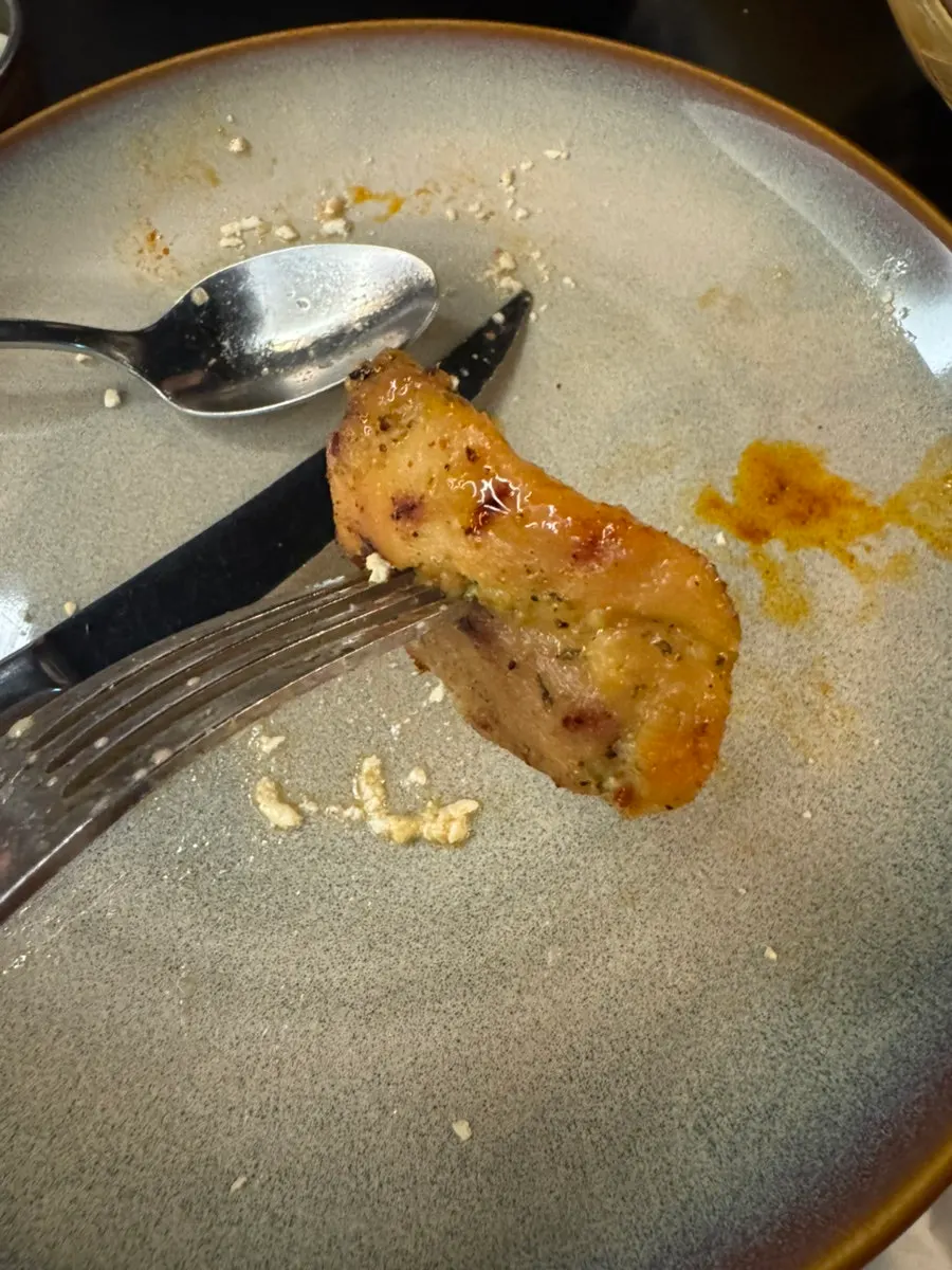 A piece of chicken picked up mid-bite