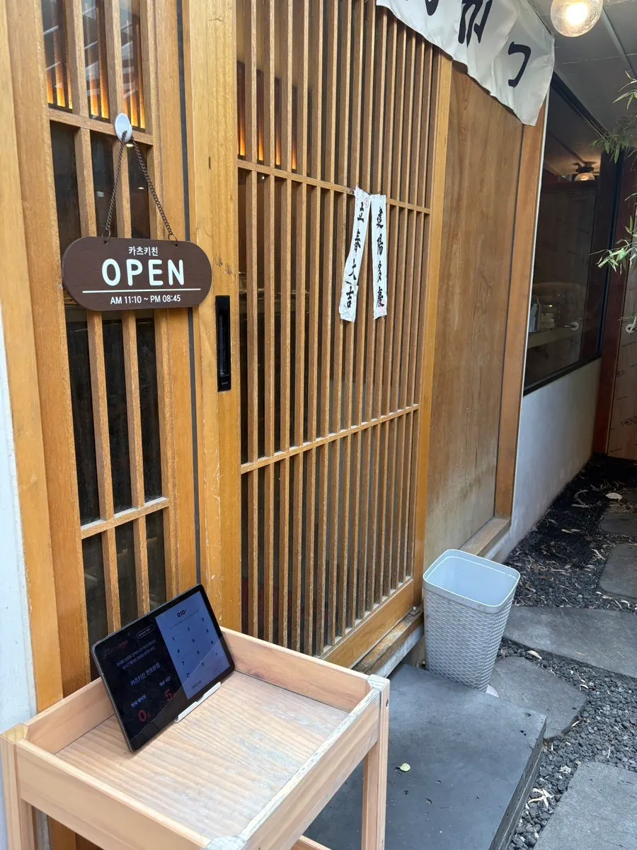 Katsu Kitchen sign inside a passage lined with several shops