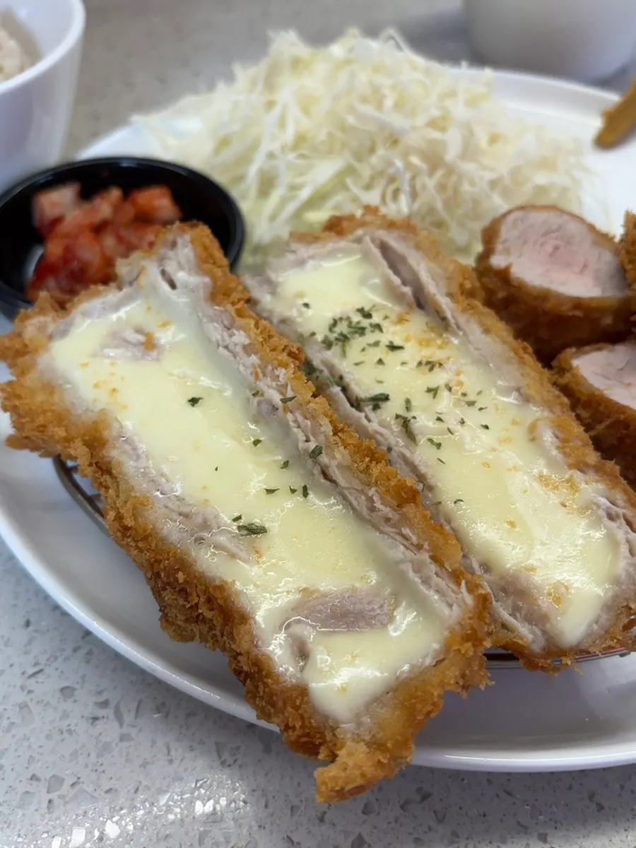 Cross-section of cheese katsu with melted cheese stretching