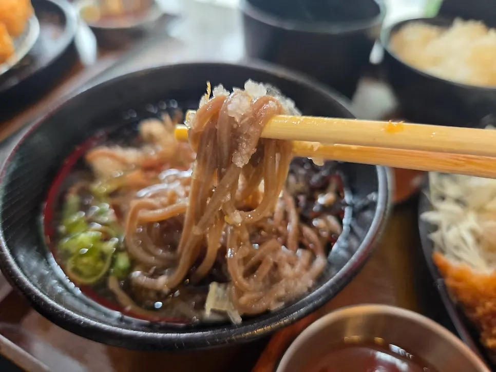 Taking a bite of cold soba noodles and broth