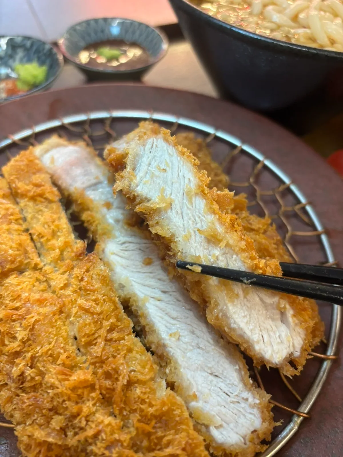 Katsuobushi broth udon with fish cake alongside the katsu