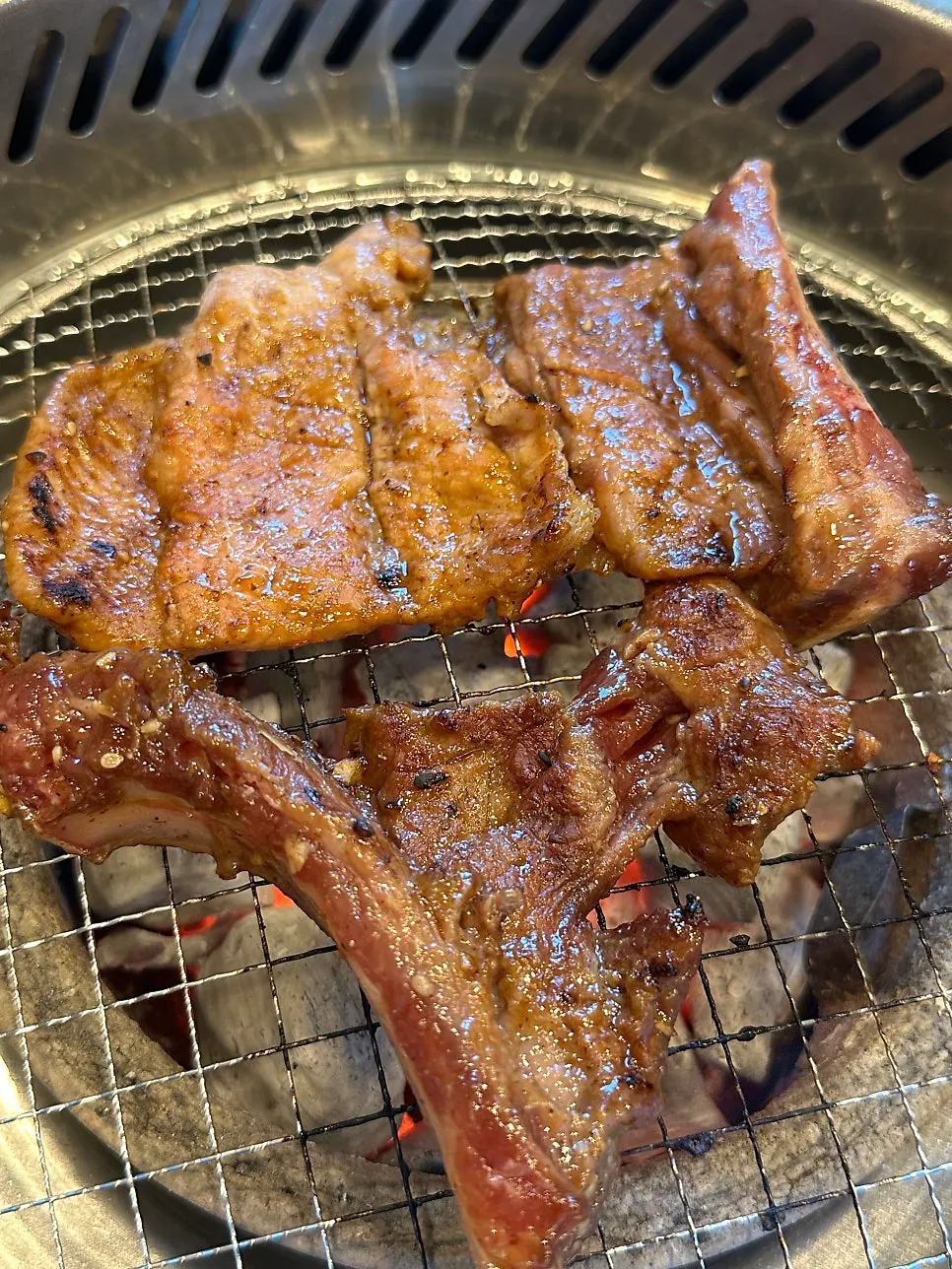 Pork galbi flipped back and forth on the grill
