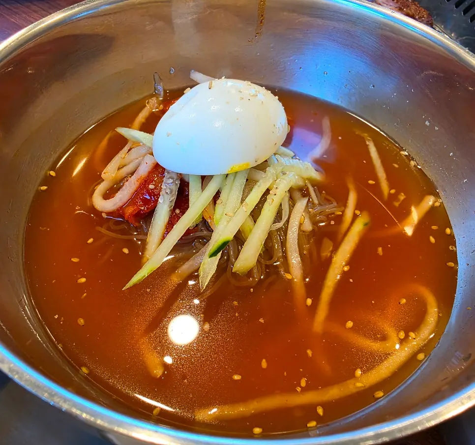 Two bowls of pollock hoe naengmyeon, water and bibim