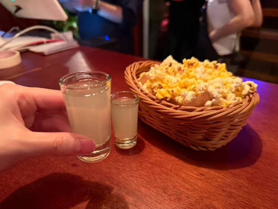 Welcome drink in a shot glass with basic popcorn snack