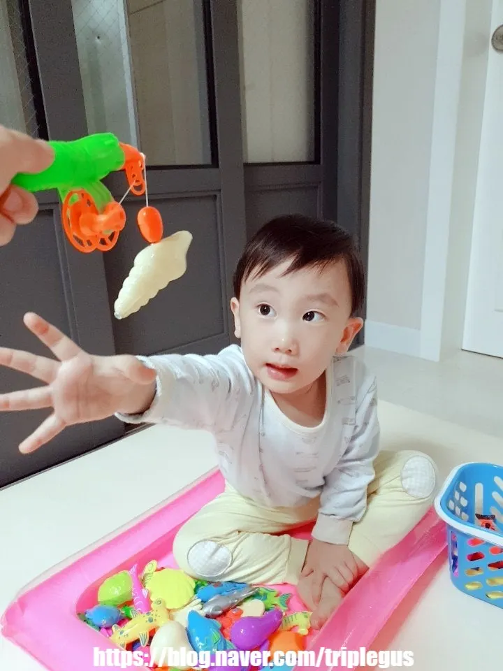 풀장 안에서 낚시놀이를 즐기는 유아
