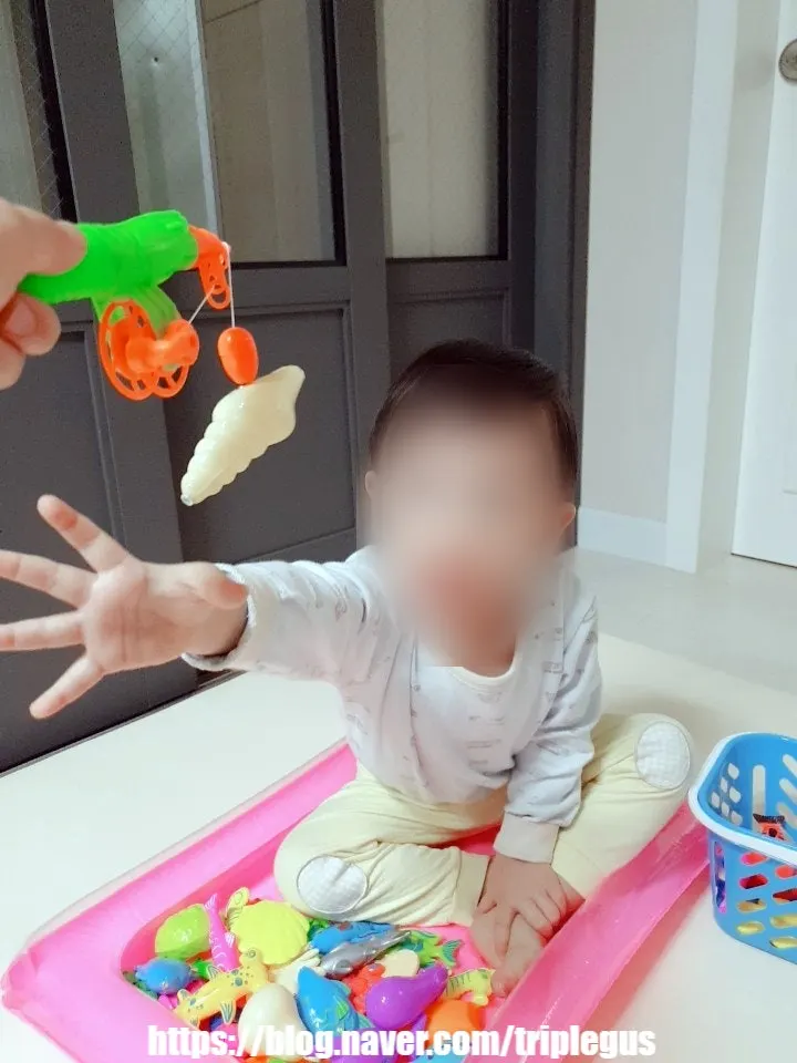 プールの中で釣り遊びを楽しむ幼児