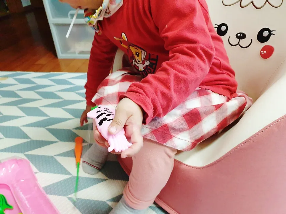 Child examining a magnetic fish while playing