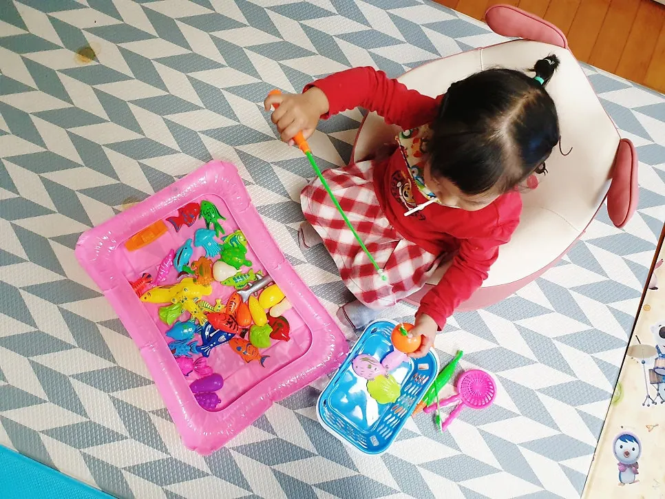 Child playing with a fishing rod and fish