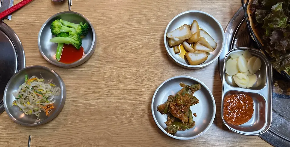 A spread of side dishes served with the grilled meat