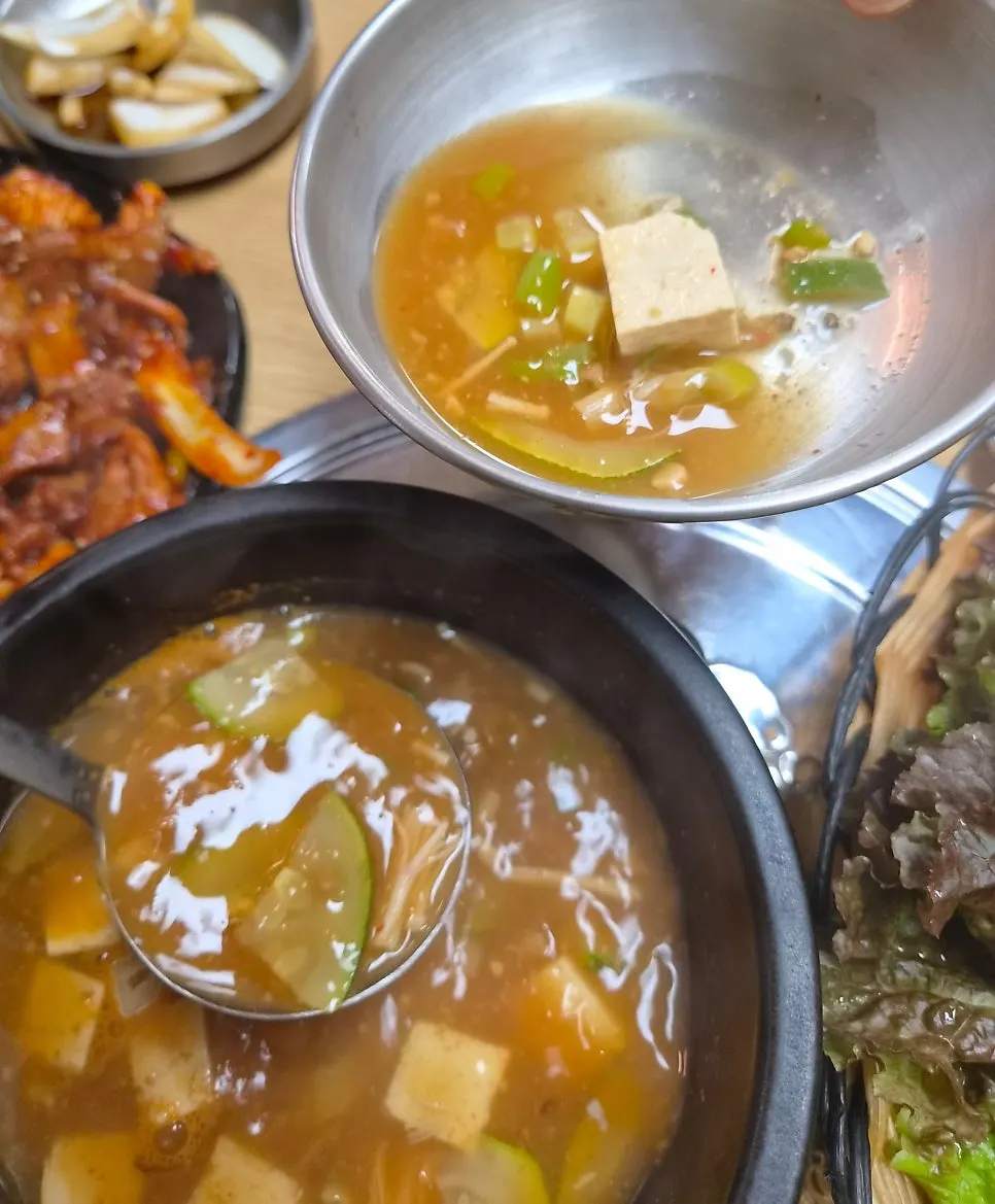 A full meal setting with grilled meat and doenjang stew