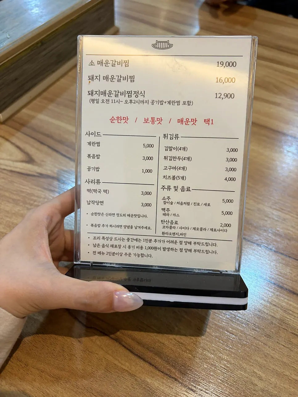 Menu board listing beef and pork spicy galbijjim and spice levels