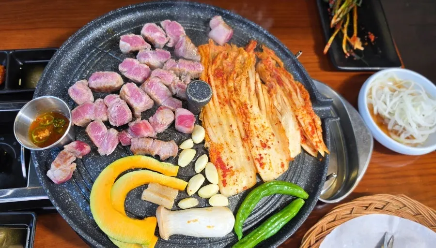 솥뚜껑에 구워지는 목살과 김치