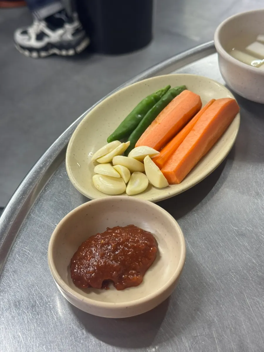 Side dishes of cheongyang peppers, garlic, and carrot ssamjang