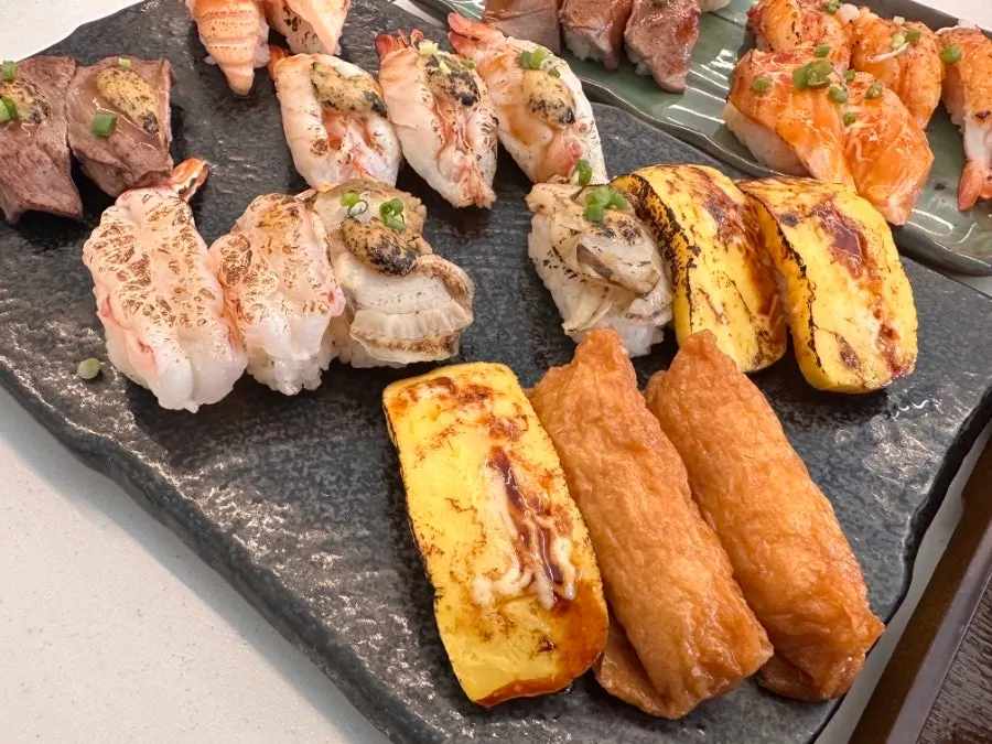 Flame-seared sushi neatly arranged on a plate