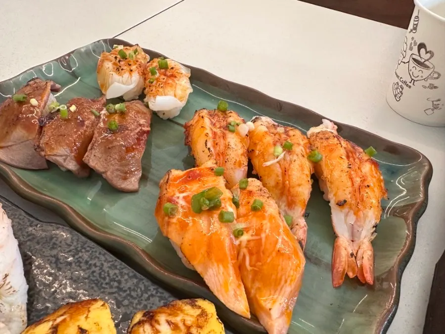The flame-seared sushi set plated together with the side dishes