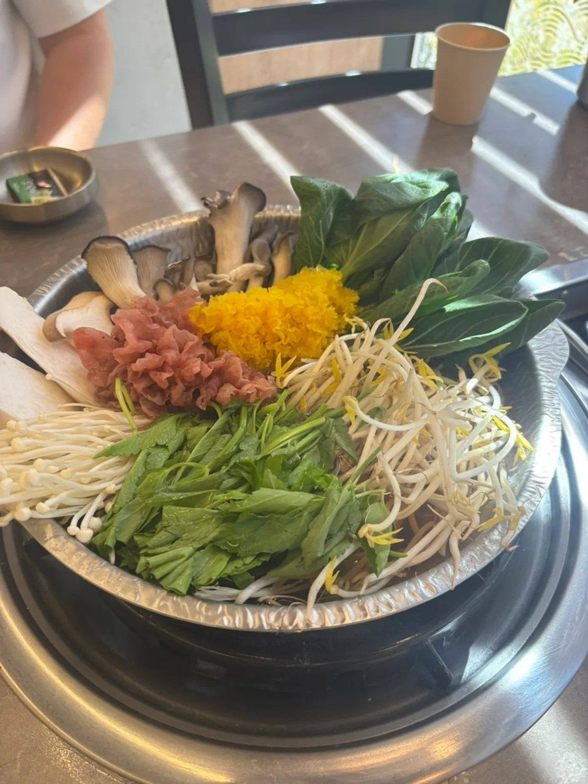 Plate of shabu-shabu vegetables with various mushrooms, bean sprouts and herbs