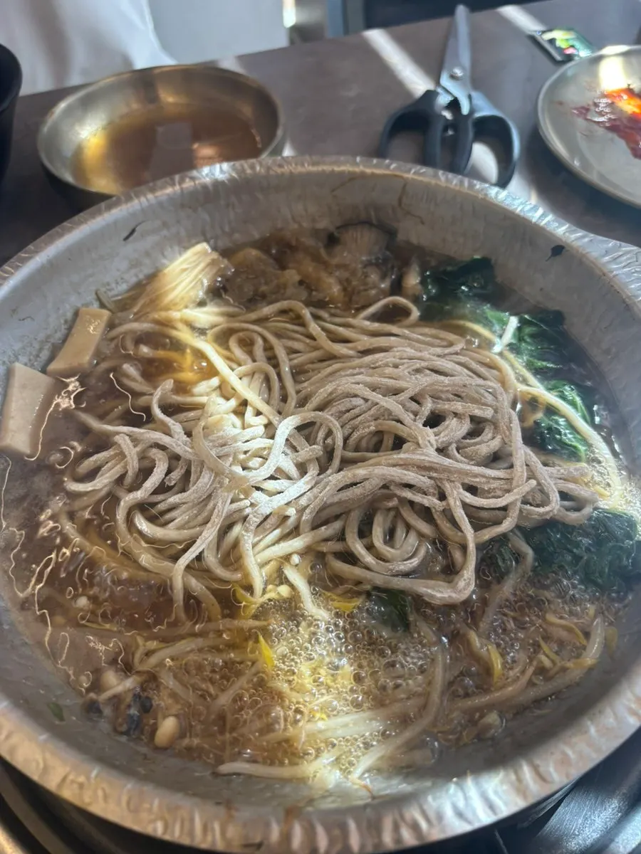 A piece of shabu-shabu meat dipped in soy sauce