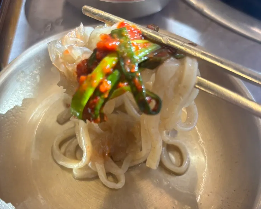 Kalguksu noodles lifted from the thickened broth
