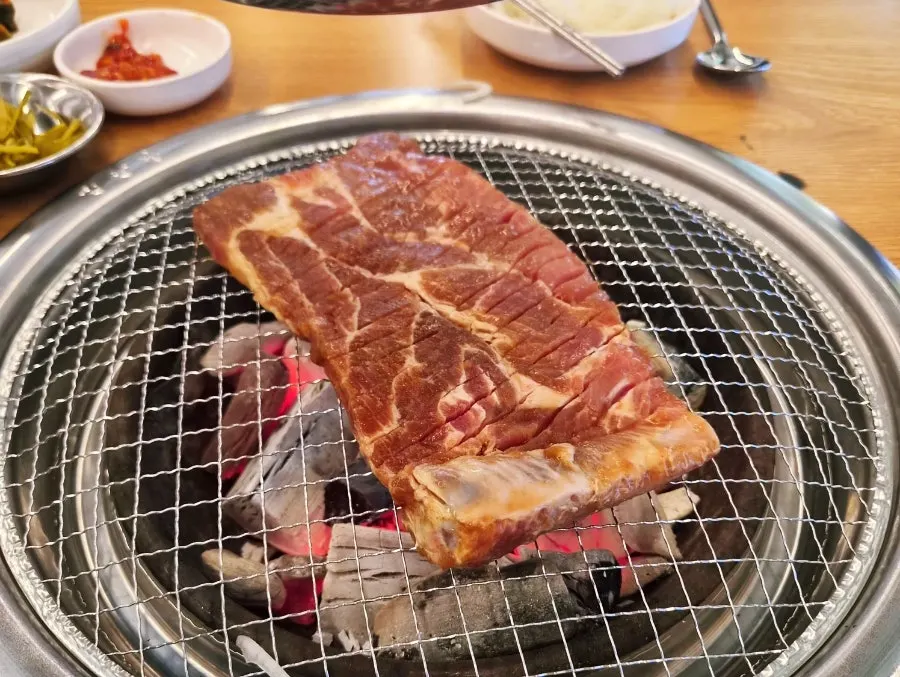 Handmade king pork ribs grilling over charcoal