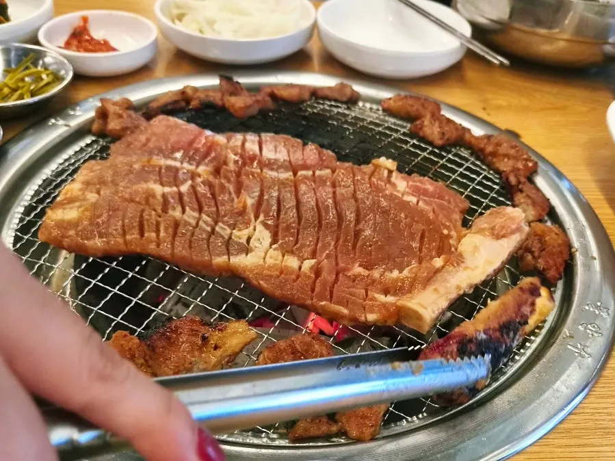 Flipping marinated pork ribs over charcoal