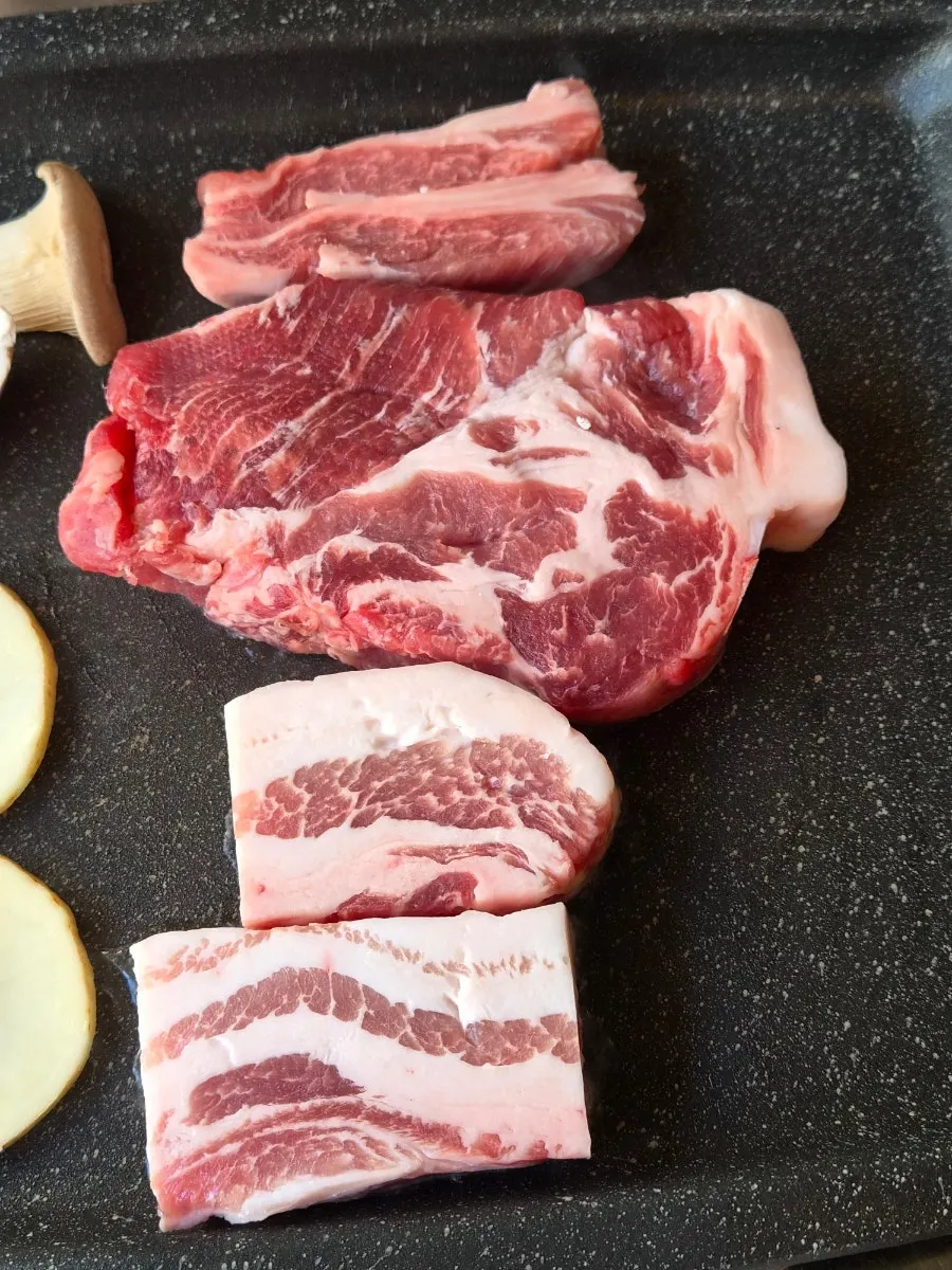 Staff grilling the meat on the tabletop grill