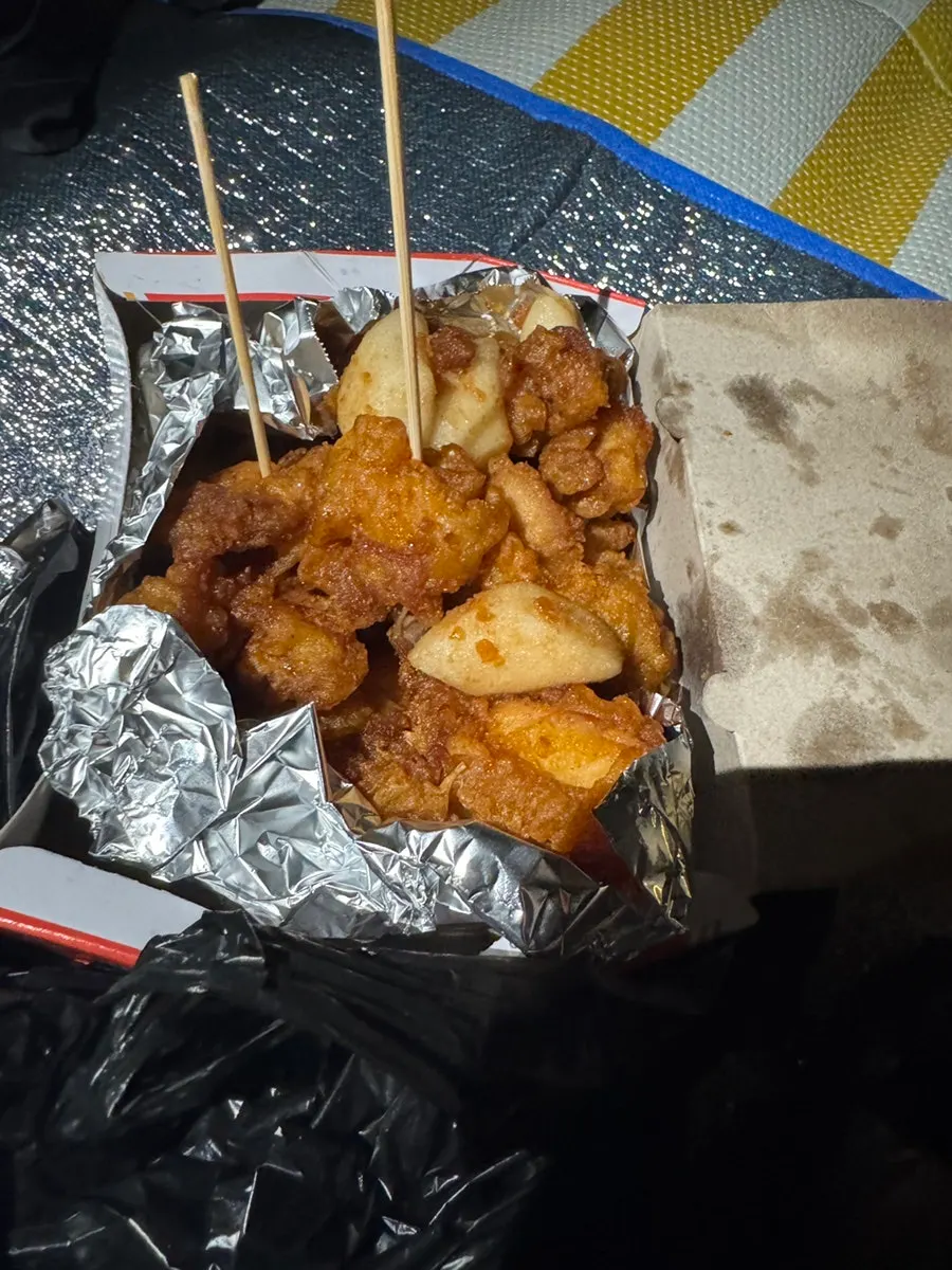A piece of dakgangjeong picked up with a skewer