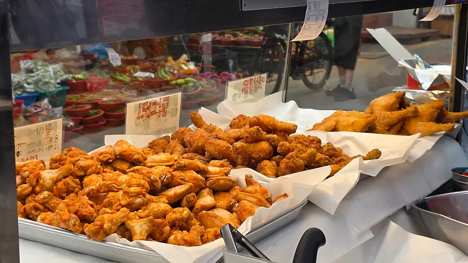 Dakgangjeong being tossed in sauce during preparation
