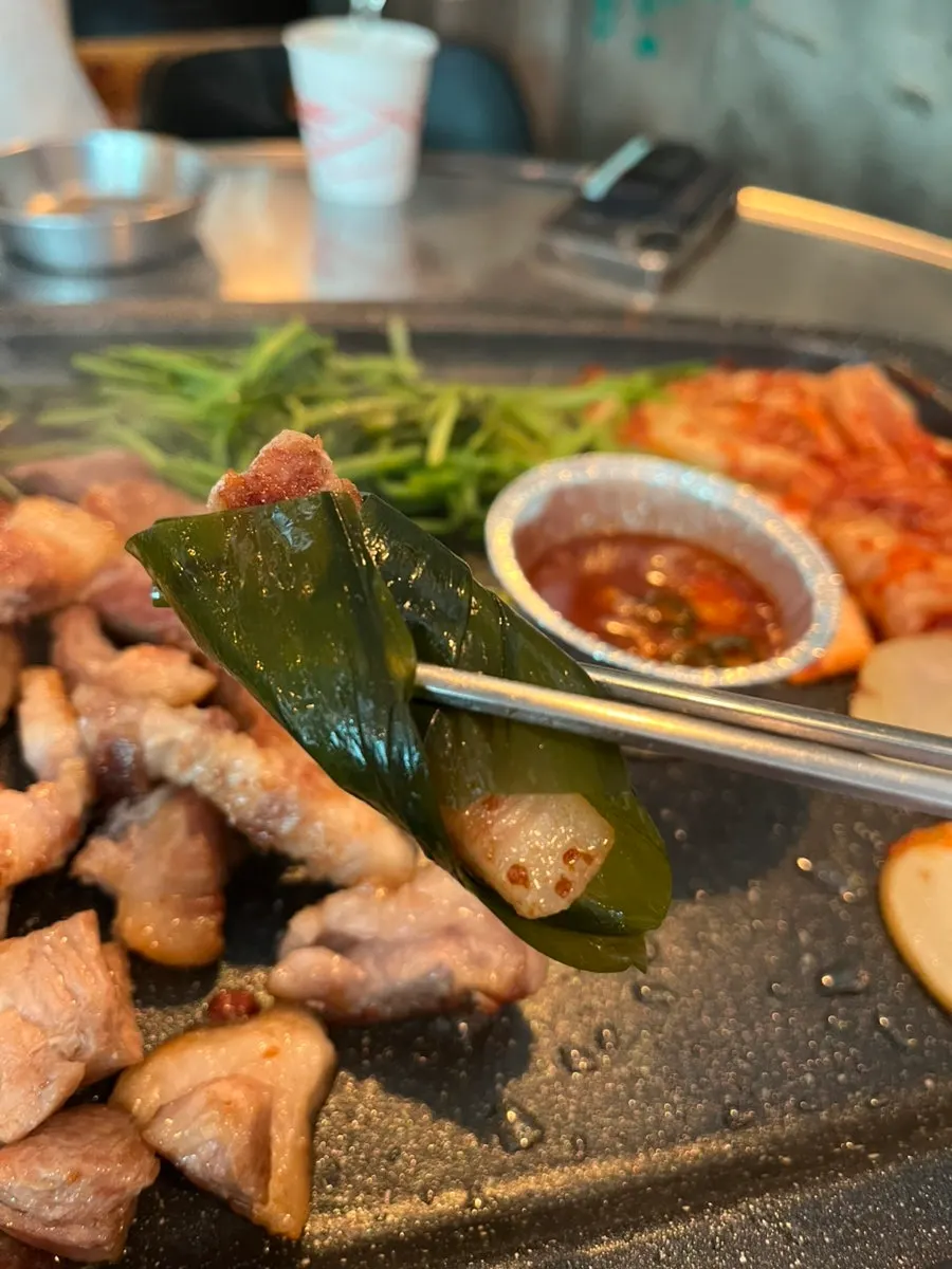 구운 미나리를 올린 고기 한 점