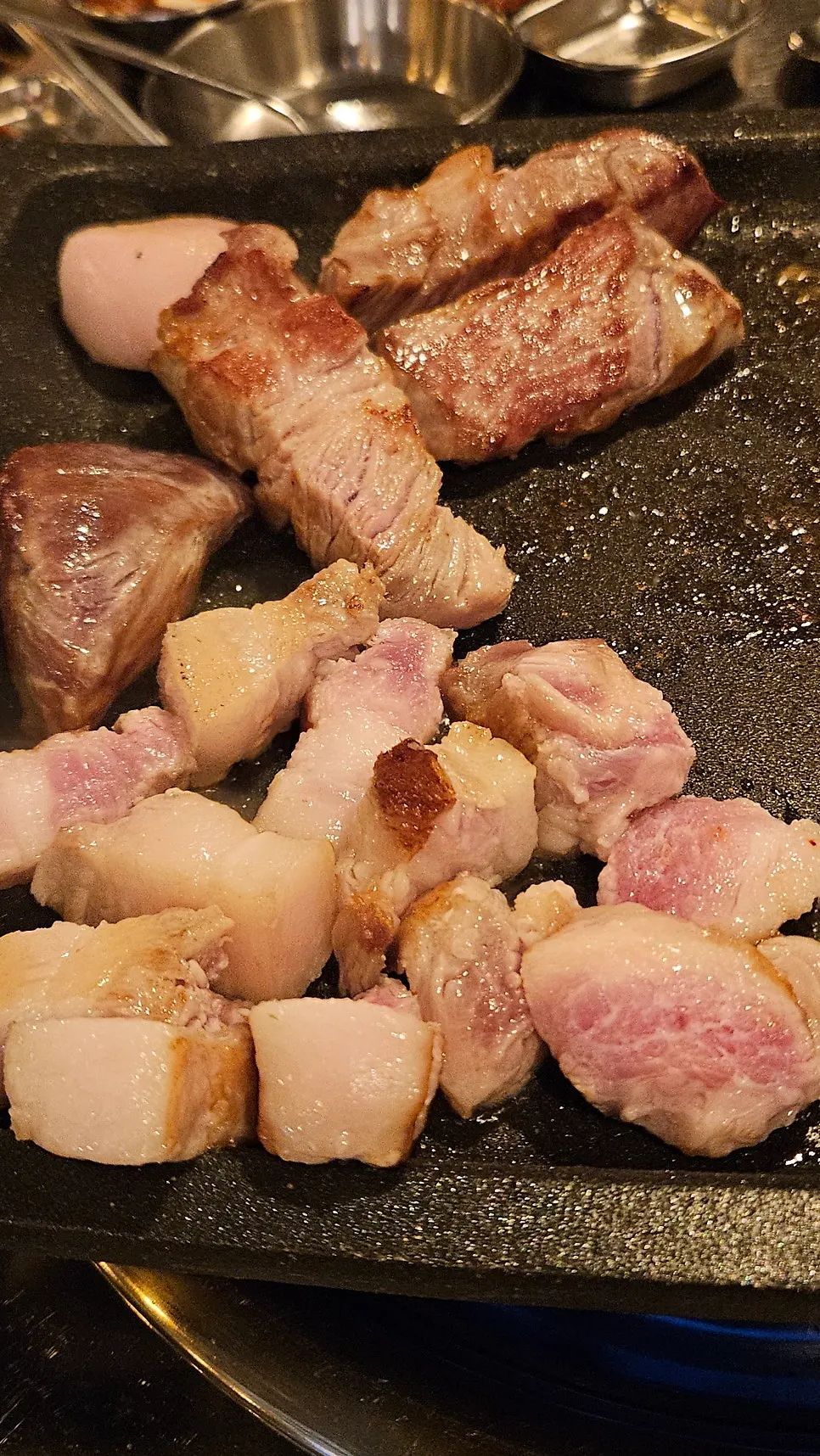 A piece of aged pork belly topped with minari